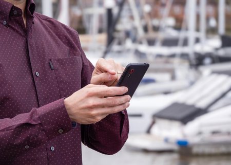 Hands On Phone With Boats In Background NW Mixed Content Block 952X664